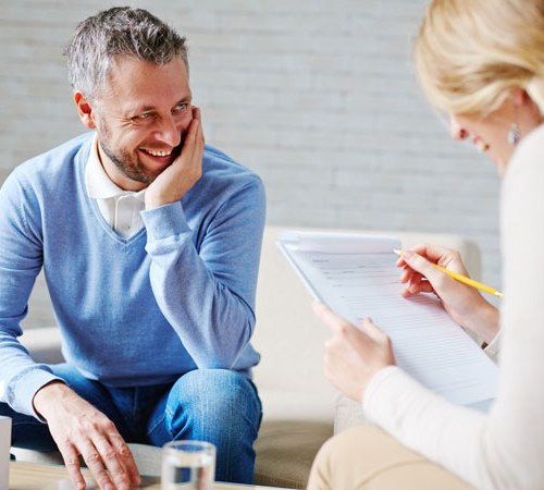 Homme et femme en train de converser assis à une table basse