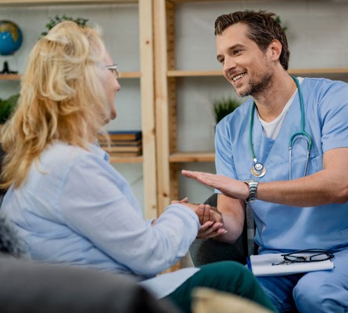 Homme médecin qui réconforte une patiente