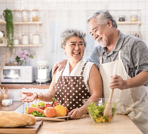 Homme et femme âgés qui préparent de la nourriture saine dans une cuisine