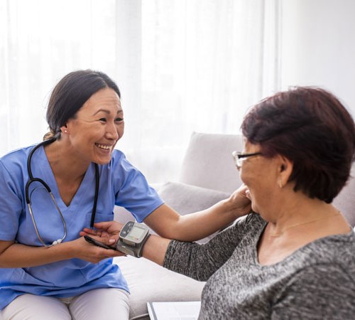 woman doctor assessing a patient while sitting on a couch