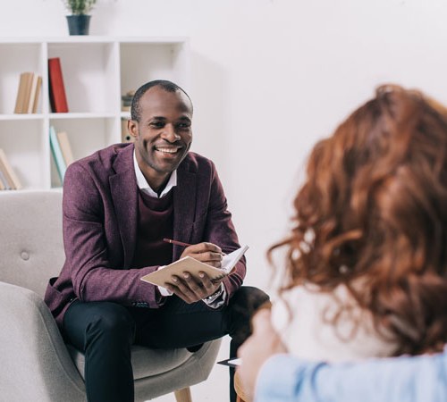 Foundations-of-Motivational-Interviewing Man and woman in an office having a discussion